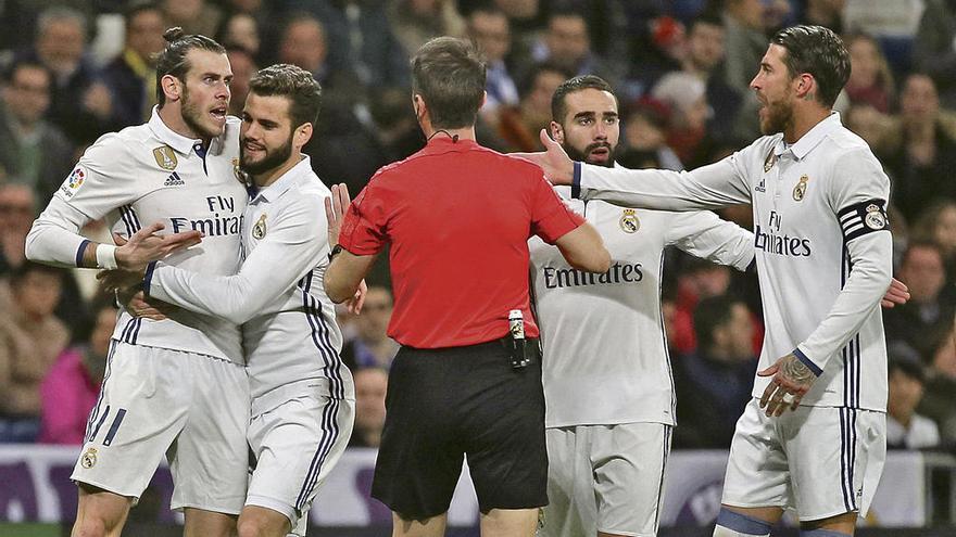 Nacho sujeta a Bale mientras Fernández Borbalán se echa la mano al bolsillo para sacar la tarjeta roja.