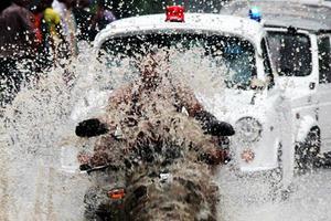 Un home circula amb la seva motocicleta pels carrers de Nova Delhi malgrat trobar-se en plena temporada del monsó (Índia).