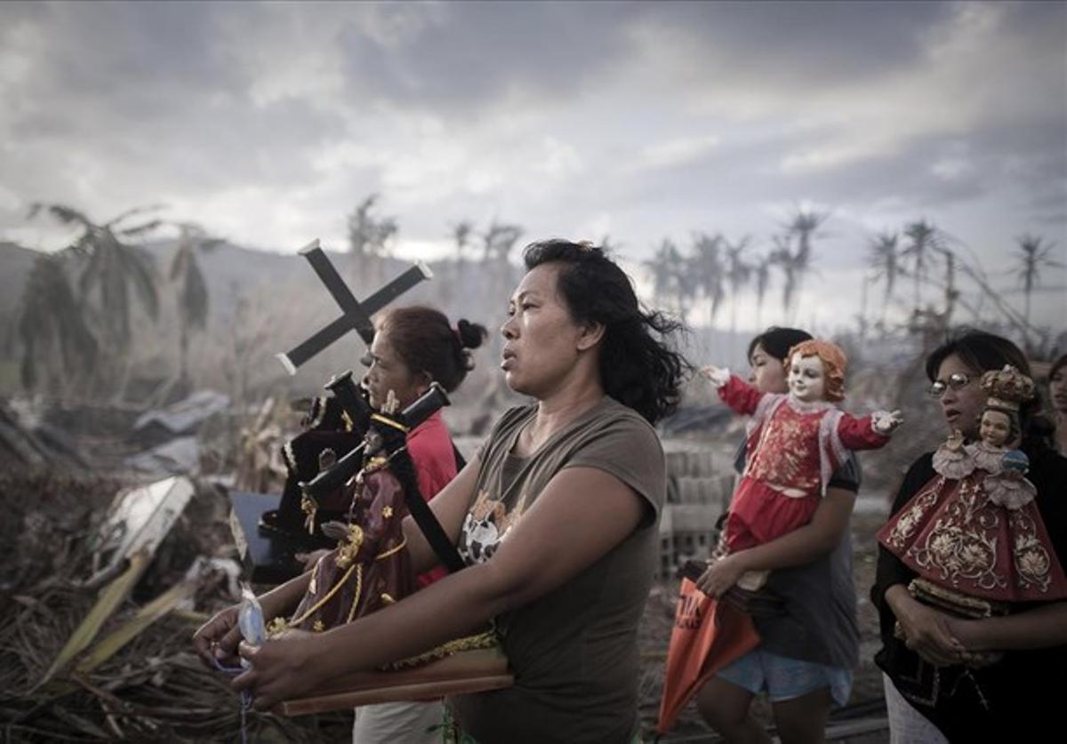 Supervivents del tifó ’Haiyan’ marxant durant una processó religiosa a Tolosa, Filipines, el 18 de novembre del 2013.