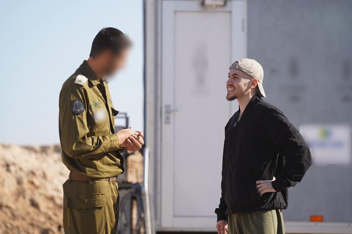 Un miembro del Ejército de Israel conversa con Eitan Mor, uno de los rehenes liberados por Hamás.