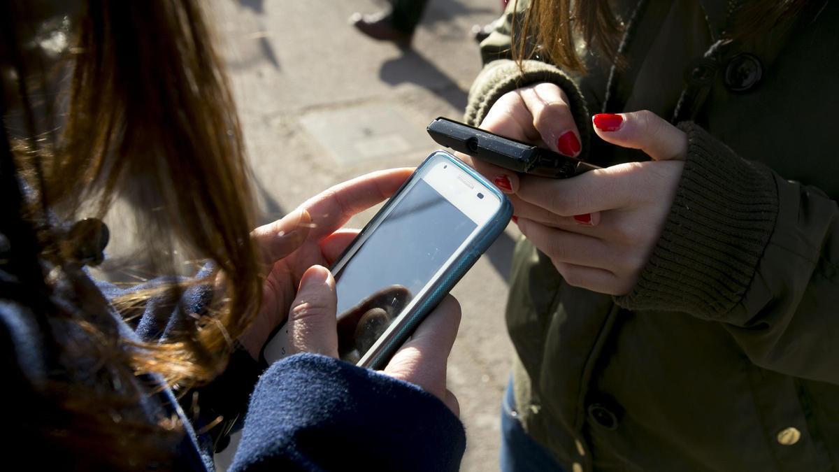 Adolescentes utilizando telefono movil.