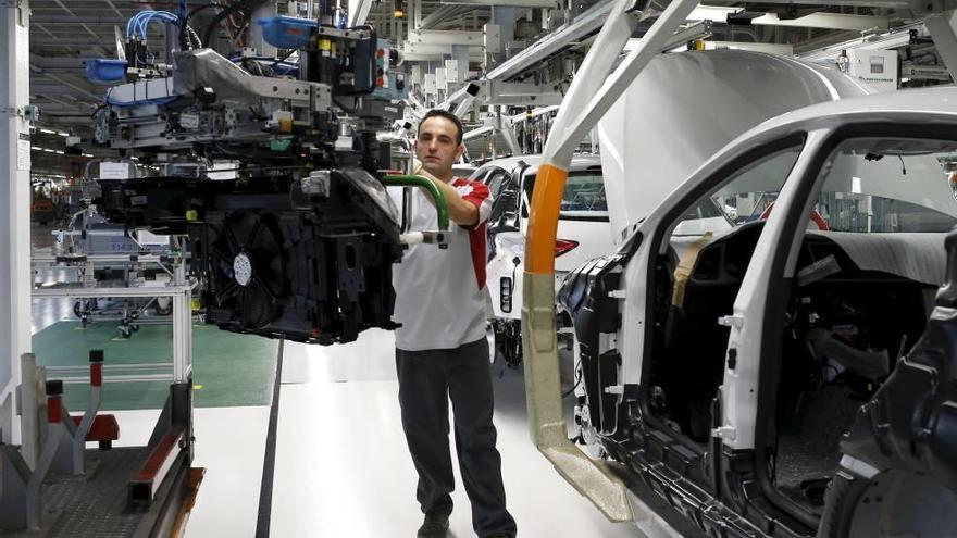 Un operario de la fábrica Seat de Martorell, en Barcelona, coloca un motor Volkswagen a un modelo Seat León.