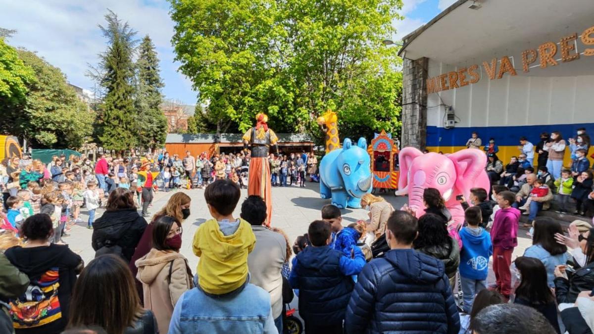 Arriba, espectáculo infantil en el parque Jovellanos. En el círculo, clientes en uno de los puestos. | A.V.