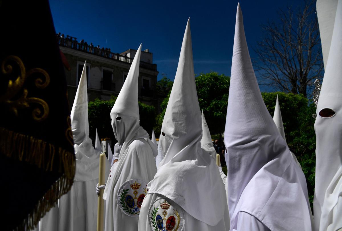 Penitentes de la hermandad de La Paz participan en la procesión del Domingo de Ramos en Sevilla