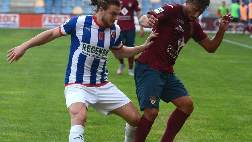 Mouriño disputa un balón con el jugador del Izarra Sam Piette, en el encuentro de la primera vuelta . // Rafa Vázquez