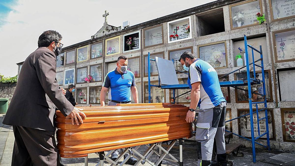 Trabajadores de la funeraria y del cementerio realizan en solitario la inhumación.   | // ANXO GUTIÉRREZ