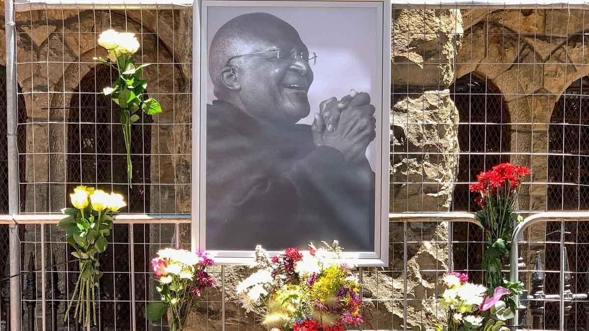 Flores junto a un retrato de Desmond Tutu, en el exterior de la catedral de San Jorge, en Ciudad del Cabo, el 26 de diciembre del 2021, tras conocerse la muerte del arzobispo.