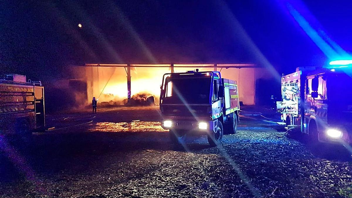 Arriba, labores de extinción del incendio de Berres. Derecha, Emerxencias y Guardia Civil, ayer, junto a la nave con restos humeantes. |  // BERNABÉ / JAVIER LALÍN