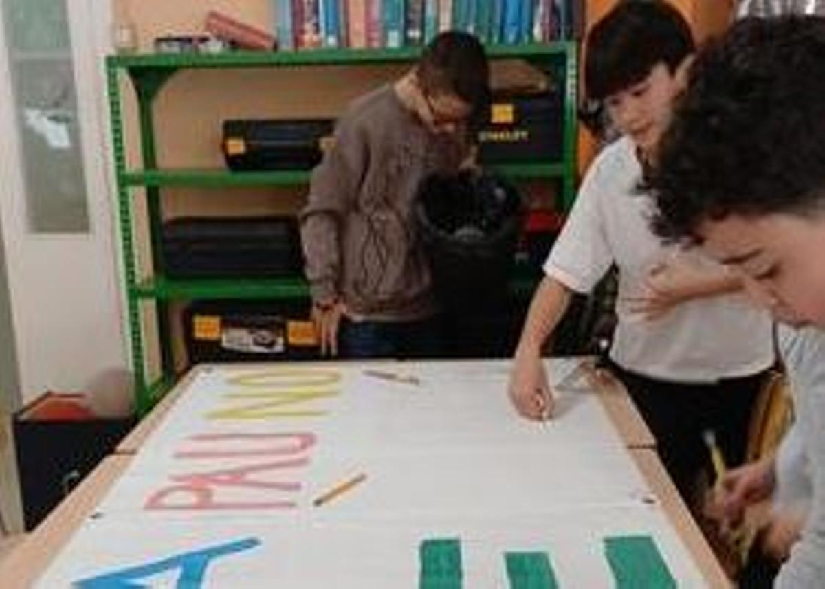 Alumnes preparant cartells per l'acte de divendres