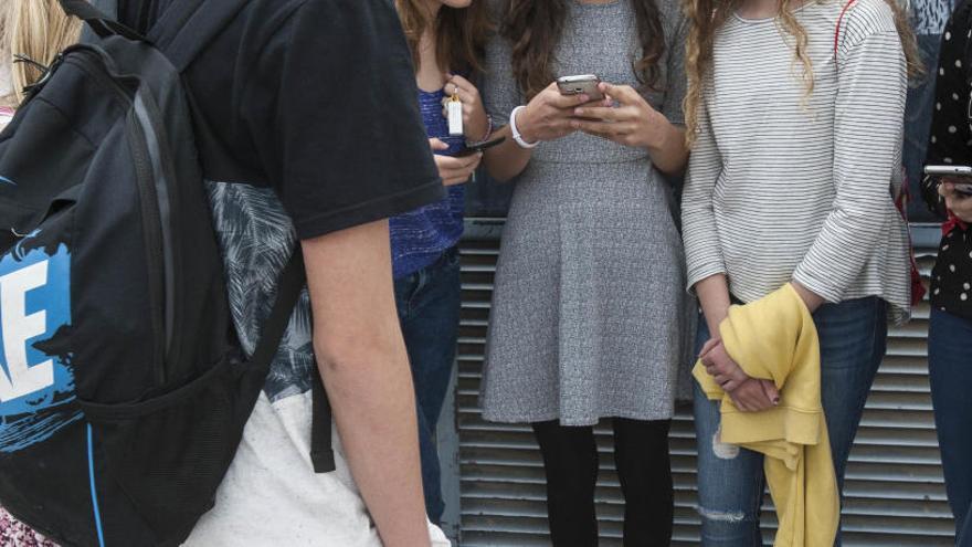 Un grupo de adolescentes haciendo uso de sus teléfonos móviles.