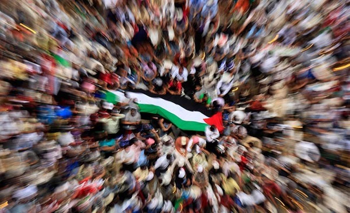 Ciutadans egipcis exhibeixen una bandera palestina durant una protesta a la plaça de Tahrir, al Caire.