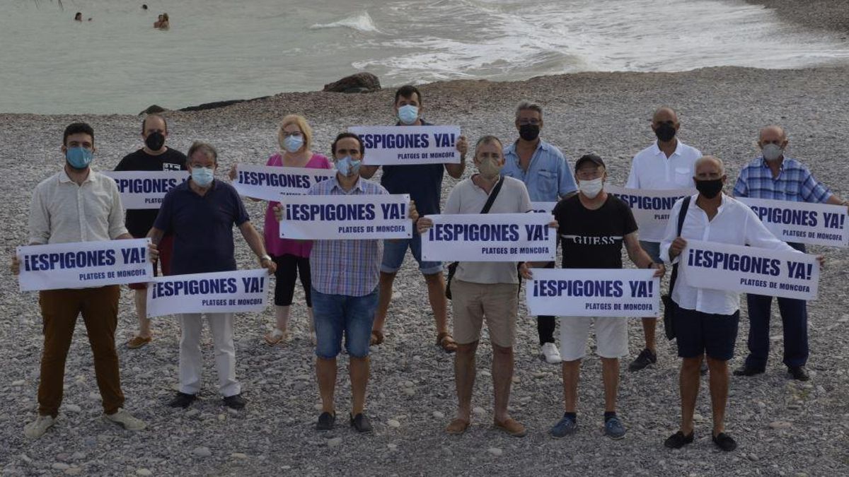 Representantes vecinales y políticos de Moncofa con pancartas reivindicando los espigones.