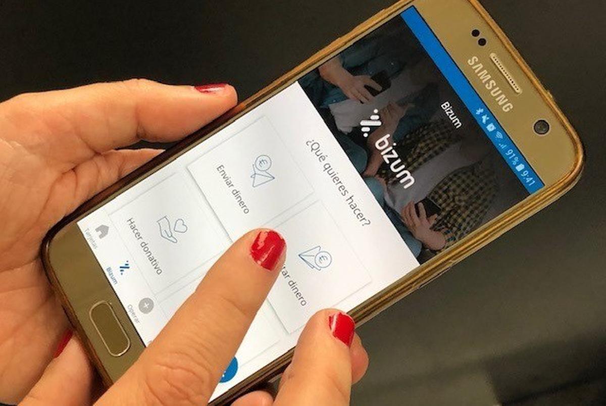 Una usuaria hace un pago con Bizum a través de su teléfono móvil.