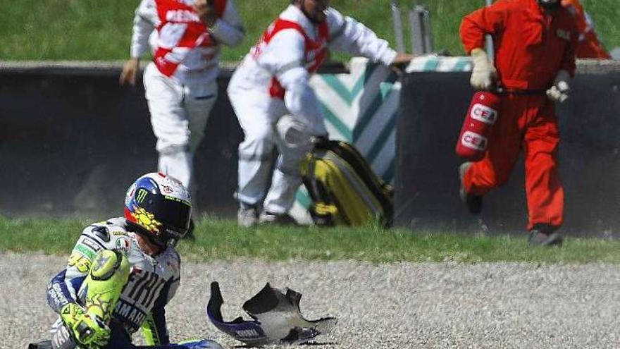 Valentino Rossi se agarra la pierna lesionada tras sufrir el accidente. / stringer