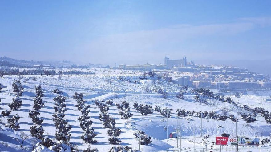 Un paisaje con la ciudad de Toledo al fondo cubierta de nieve.