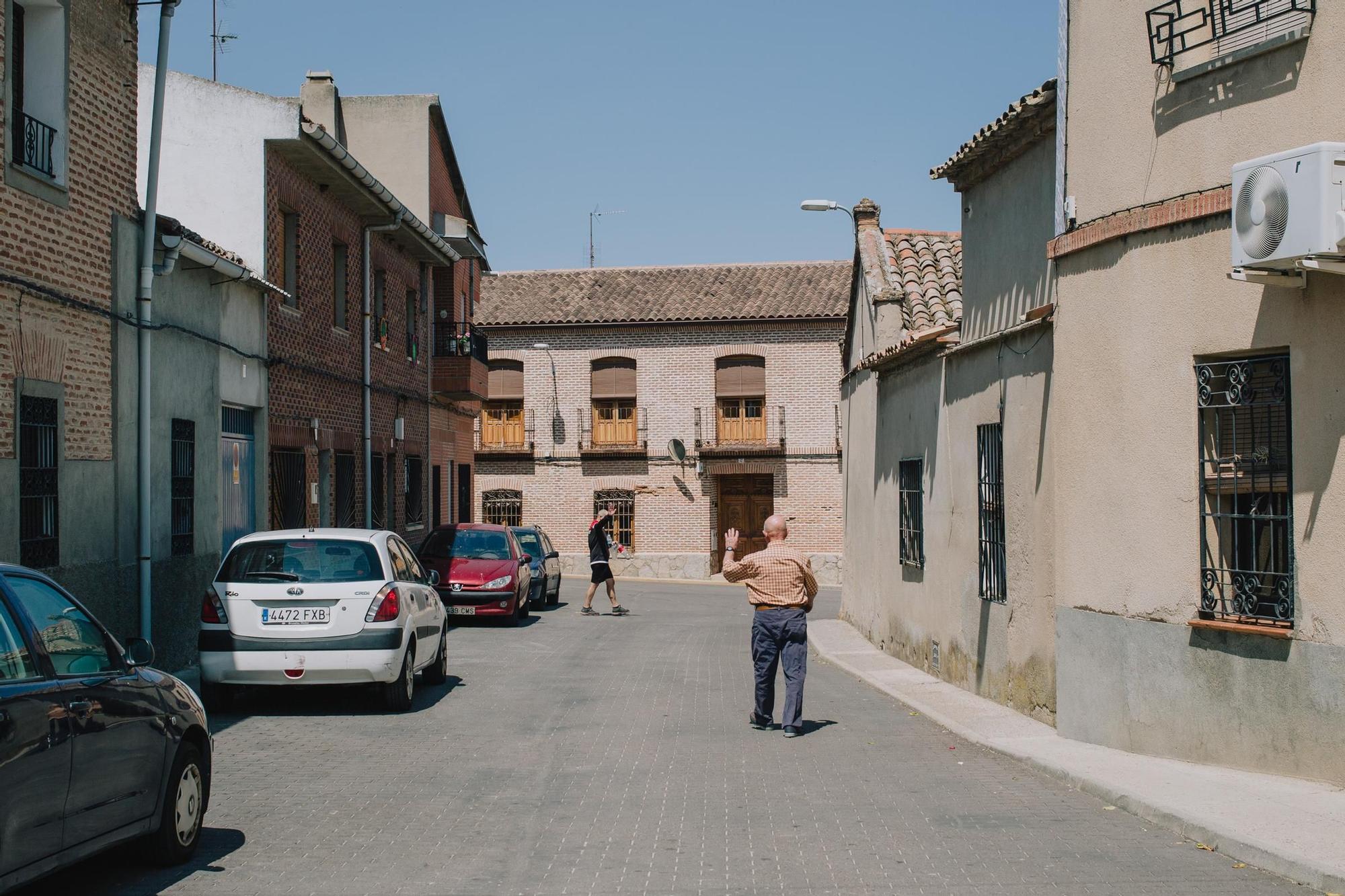 Dos vecinos de Los Cerralbos, en Toledo, se saludan por la calle.