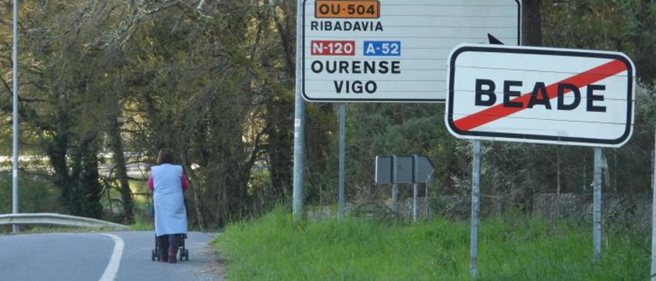 Una mujer camina sobre el fin del término municipal de Beade. |   // FERNANDO CASANOVA