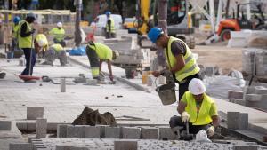 Varios trabajadores realizan obras en las Ramblas de Barcelona.