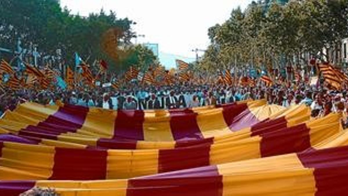 Imagen de la gran 'senyera' que encabezó la manifestación, rodeada de banderas independentistas, pocos instantes después de iniciarse el recorrido, el sábado en el paseo de Gràcia.