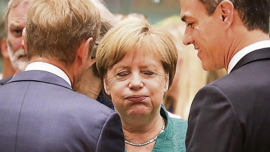 Expresivo gesto de Merkel ante Sánchez y el presidente del Consejo Europeo, Donald Tusk, de espaldas. // AFP