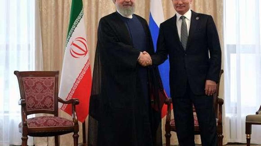 Putin estrecha la mano del presidente iraní, el viernes, durante una cumbre de la Organización de Shanghái en Kirguizistán. // Reuters