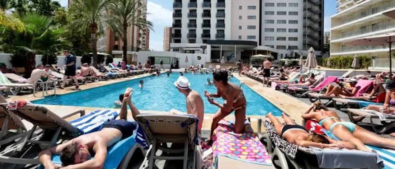 Turistas disfrutando de la piscina en un hotel de Benidorm en una imagen de este mes de octubre, en el que el buen tiempo ha prolongado la temporada alta.