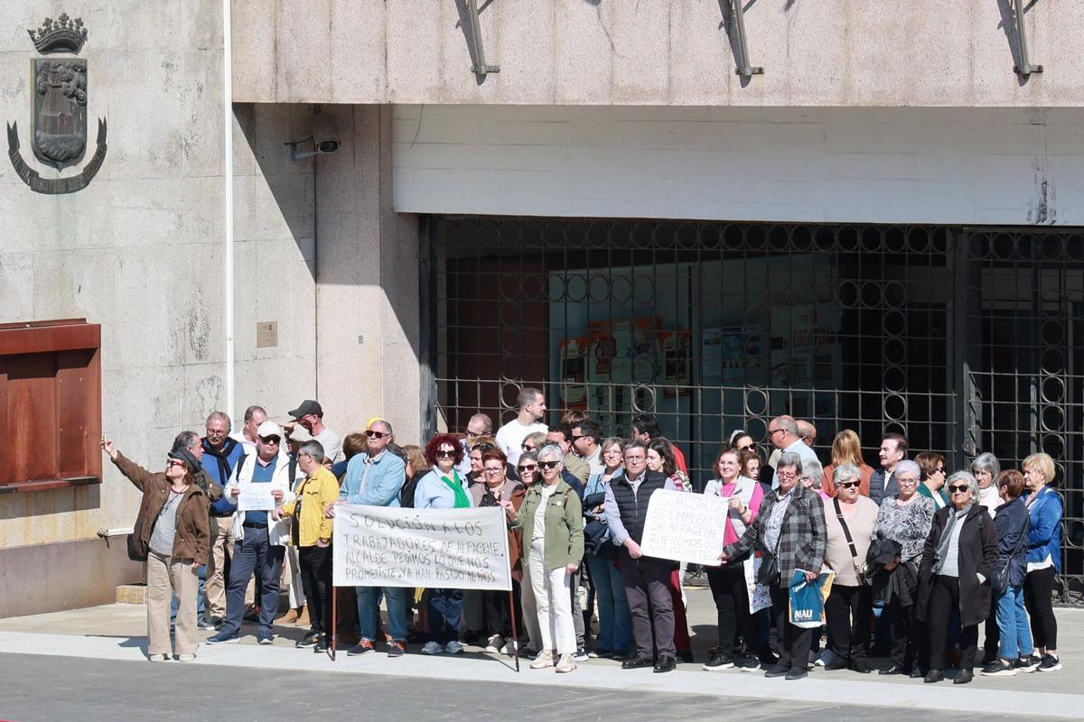Medio centenar de antiguos empleados de la fábrica conservera, ayer frente al Concello.