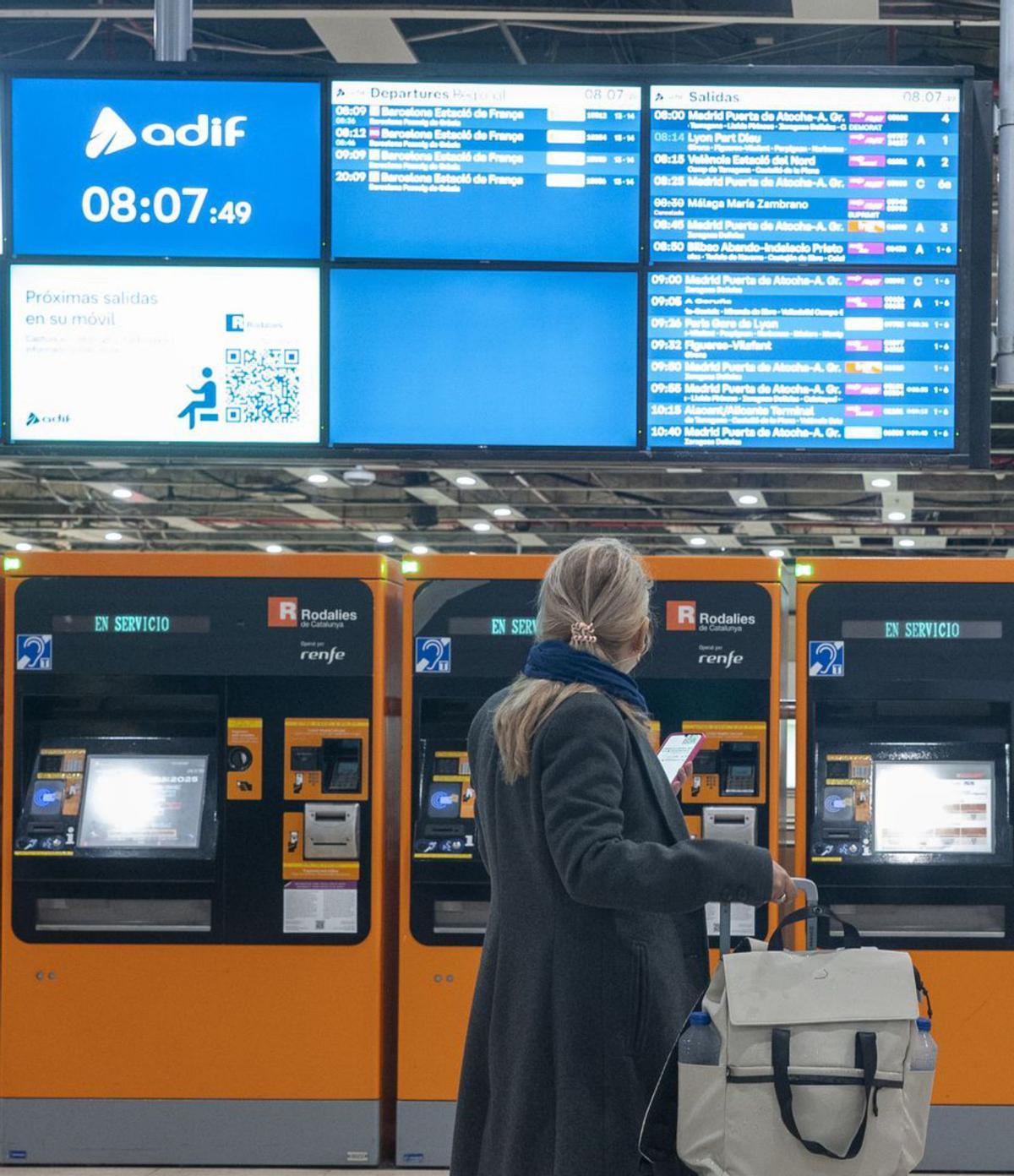 Una usuària mira les pantalles a l’estació de Sants, ahir. | JORDI COTRINA