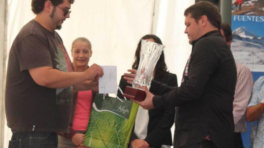 Rodrigo Llaneza, a la izquierda, recibe el premio como ganador.