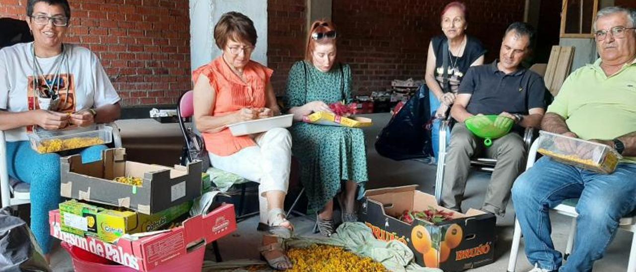 Integrantes de la asociación, trabajando ayer con el material en el bajo de la Praza Massó.   | // FDV