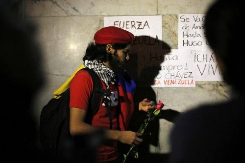 A supporter of Venezuela's President Hugo Chavez holds a rose while standing outside Venezuela's embassy in Mexico City