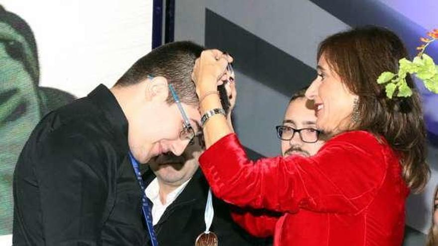 Carmen Pomar entrega la medalla a uno de los ganadores, ayer.