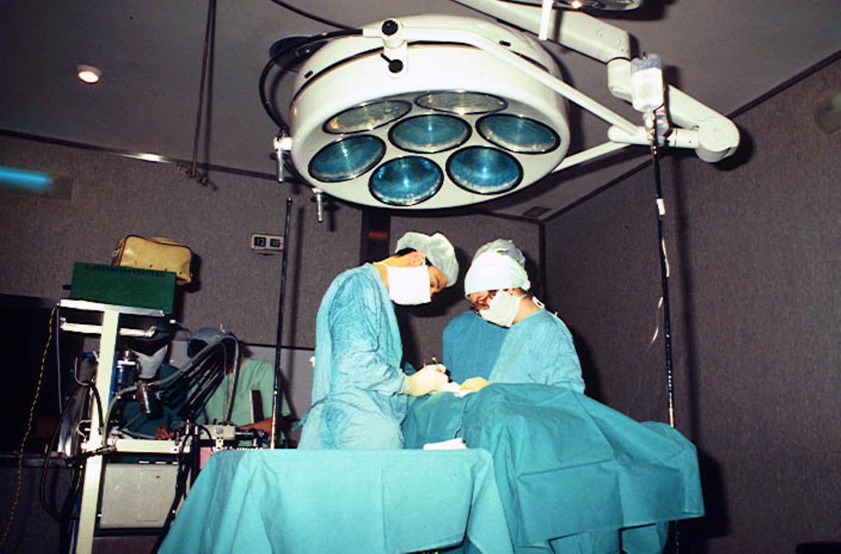 Operación hecha en uno de los antiguos quirófanos del Hospital Sant Joan de Déu Barcelona, en los años 70 del siglo pasado. Vista general de la mesa de operaciones y del equipo médico.
