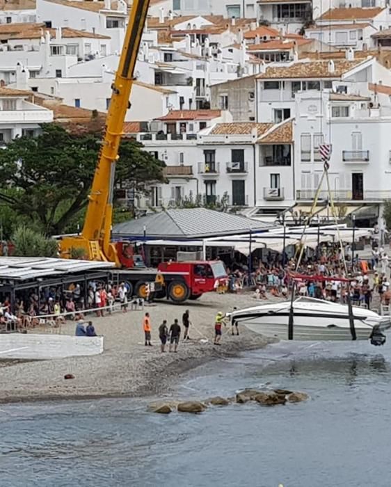 Una llanxa a la deriva s'enroca a tocar de la platja de Cadaqués