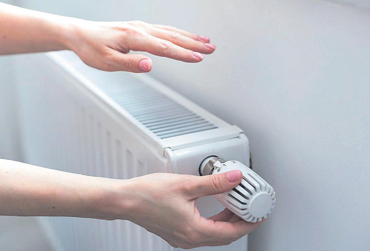 Una persona comprueba la temperatura del radiador.