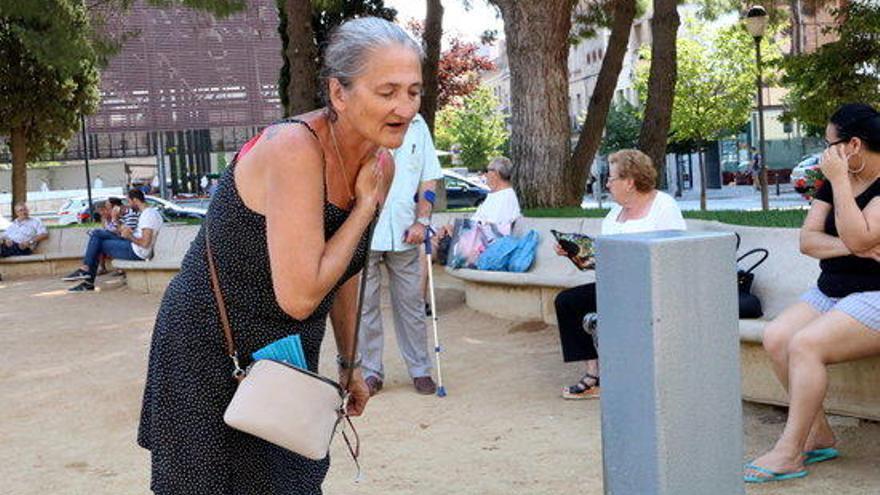 Una dona refrescant-se en una font de Figueres.