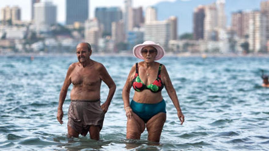 Dos turistas mayores en la playa en Benidorm