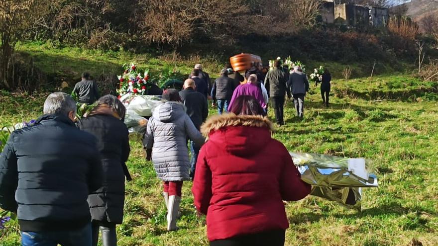 El cortejo fúnebre, ayer, atravesando la última finca antes de llegar al cementerio parroquial de San Martín de Ondes. | S. Arias