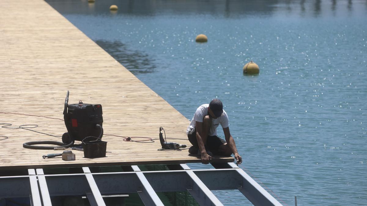 Un técnico ajustando este martes la plataforma de madera en el paseo del puerto de Alicante.