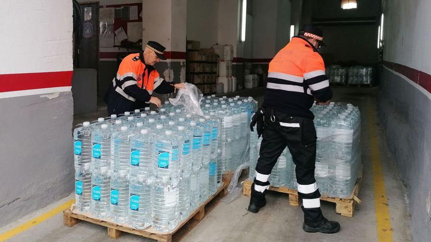 Dos voluntarios de Protección Civil organizan el reparto de agua embotellada en Toro. | M. J. C.