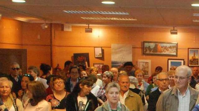 Vecinos observando los objetos realizados en el curso de cerámica, ayer en Candás.