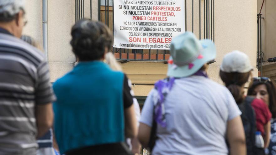 Turistas en una plaza de València con protestas vecinales