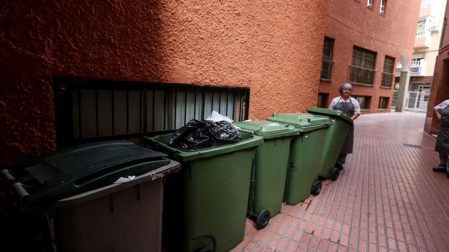 Trabajadores de un pequeño hotel del centro de Benidorm sacan a la calle los cubos de basura.