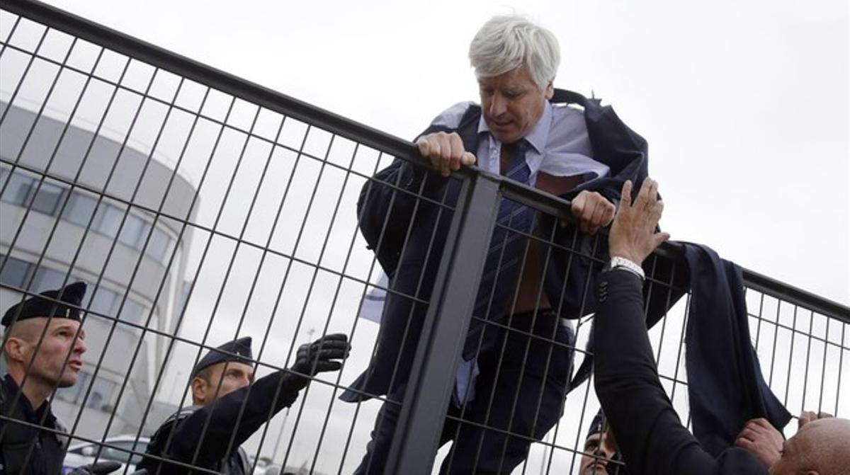 El director de Air France en Orly, Pierre Plissonnier, casi sin camisa, salta una valla para huir de los cientos de trabajadores que habían entrado en las oficinas de la compañía.