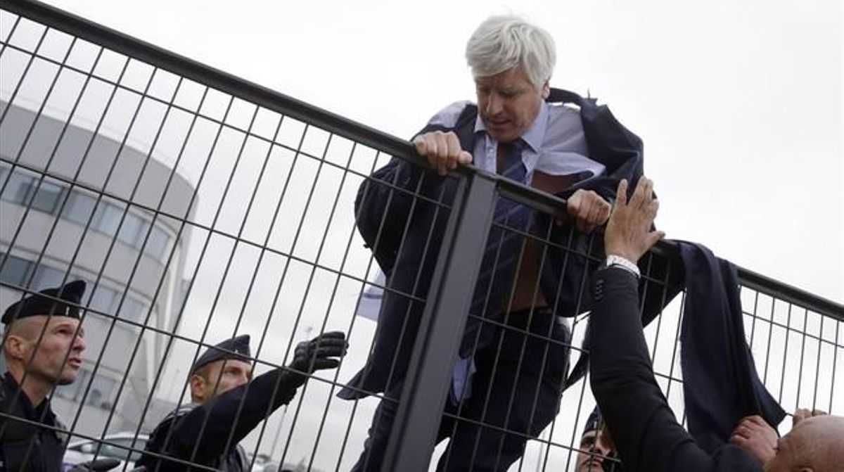 El director d’Air France a Orly, Pierre Plissonnier, gairebé sense camisa, salta una tanca per fugir dels centenars de treballadors que havien entrat a les oficines de la companyia.