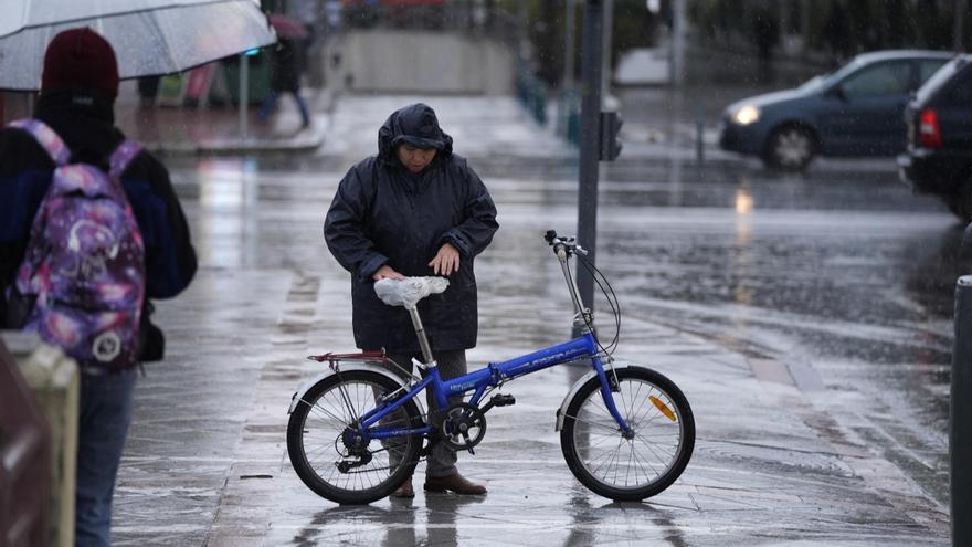 Archivo - Imagen de archivode una persona se protege de la lluvia con un impermeable.