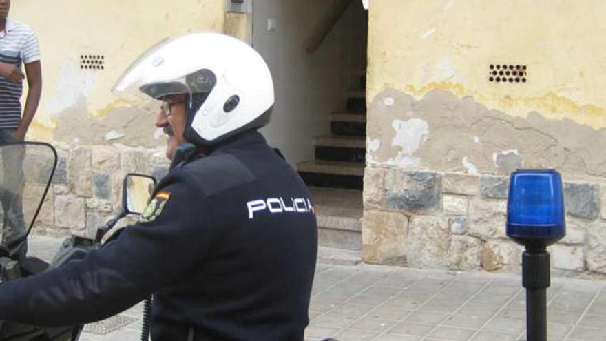 Un policía junto a un edificio donde robaron la puerta.