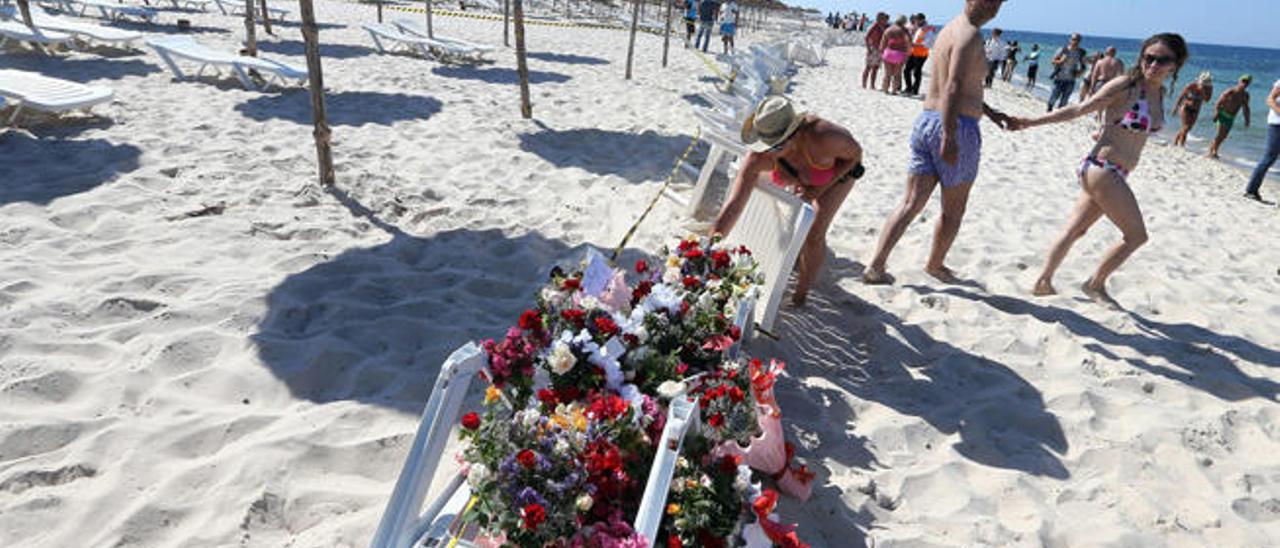 Una turista deposita flores tras el atentado en la playa de Susa, en Túnez.