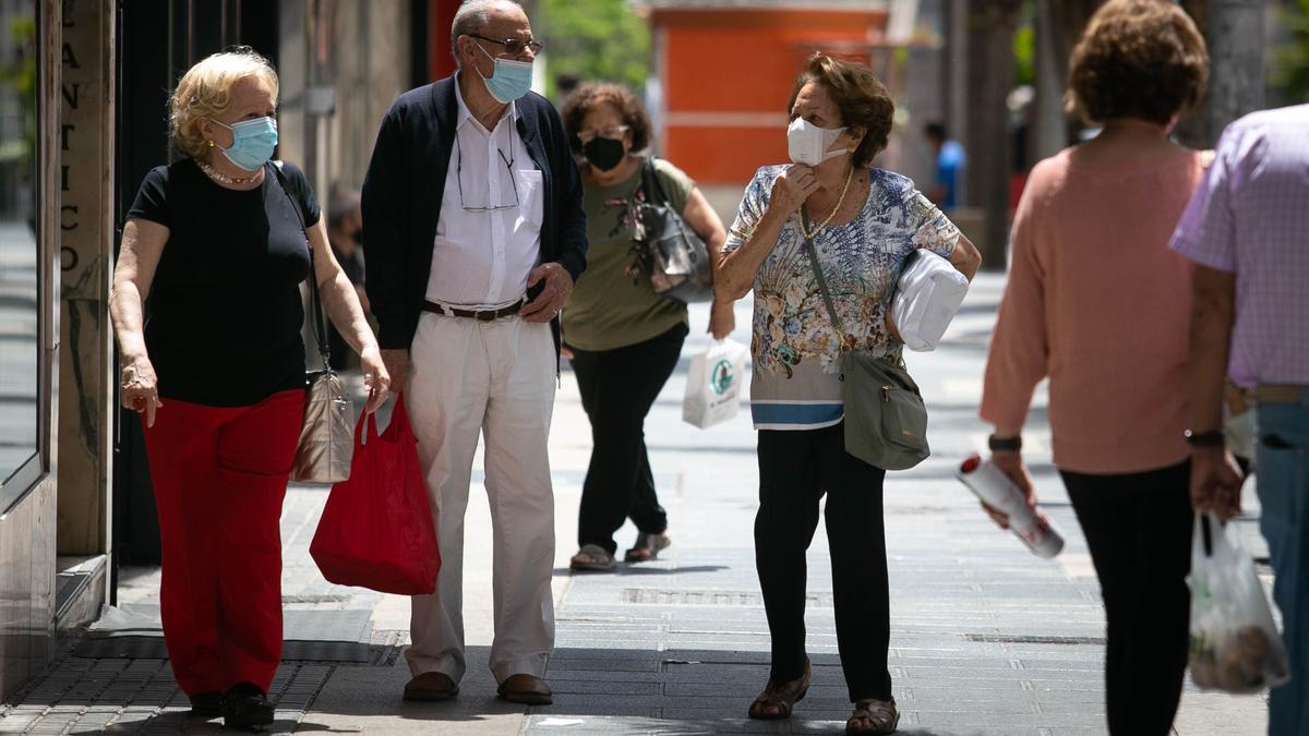 Unos mayores pasean con mascarilla por el centro de Santa Cruz de Tenerife.