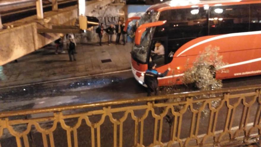 El autobús con la luna astillada, ante el puente. // FdV